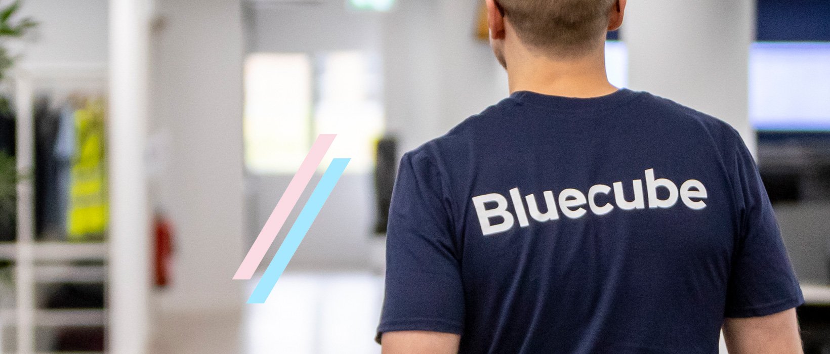 man walking through office with back turned and bluecube shirt on