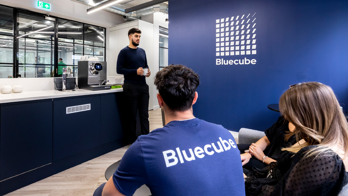 bluecube employees in reception area having a coffee